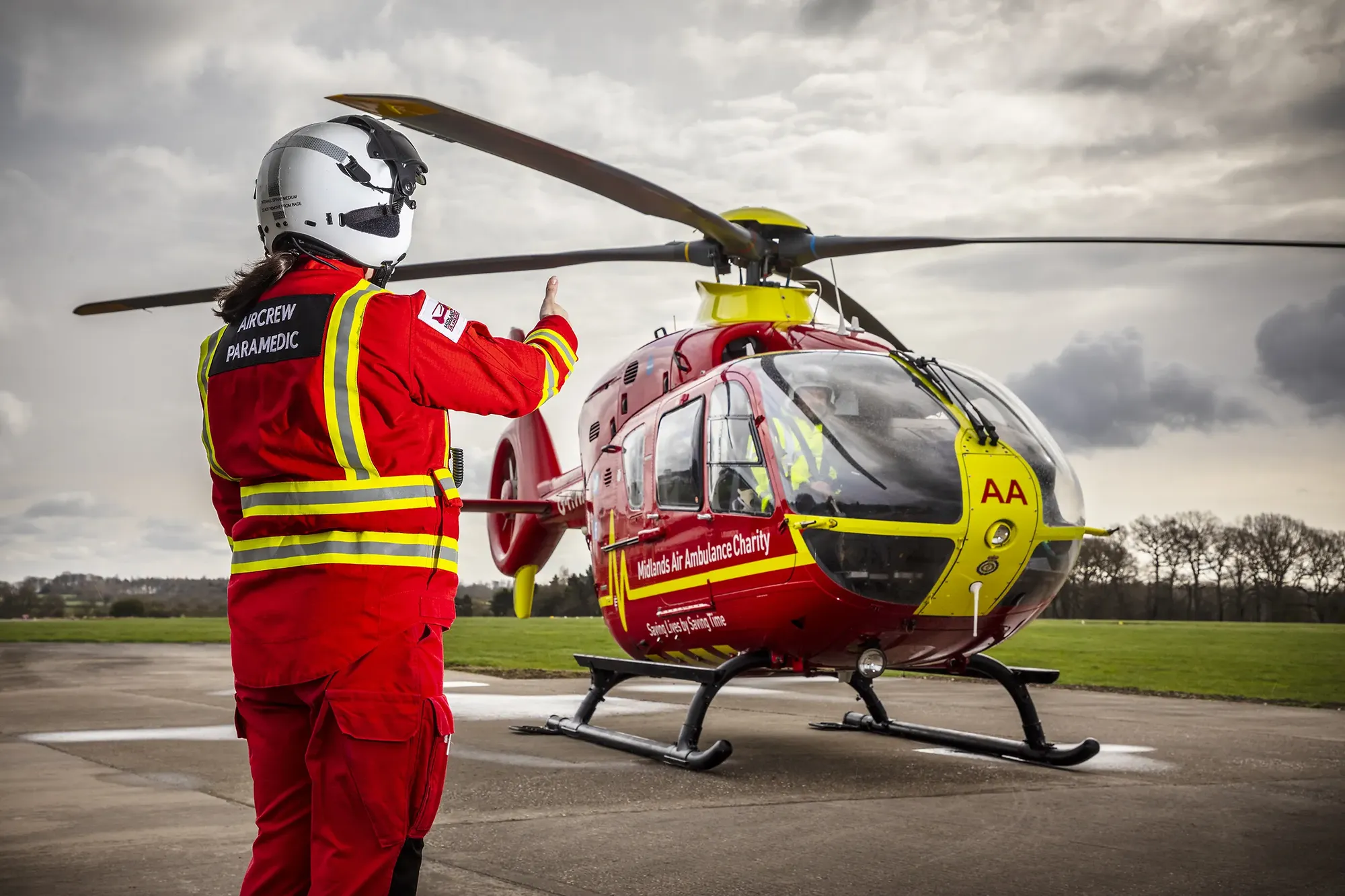 Maac Rescue Helicopter With A Man In Red Uniform Standing Next To It