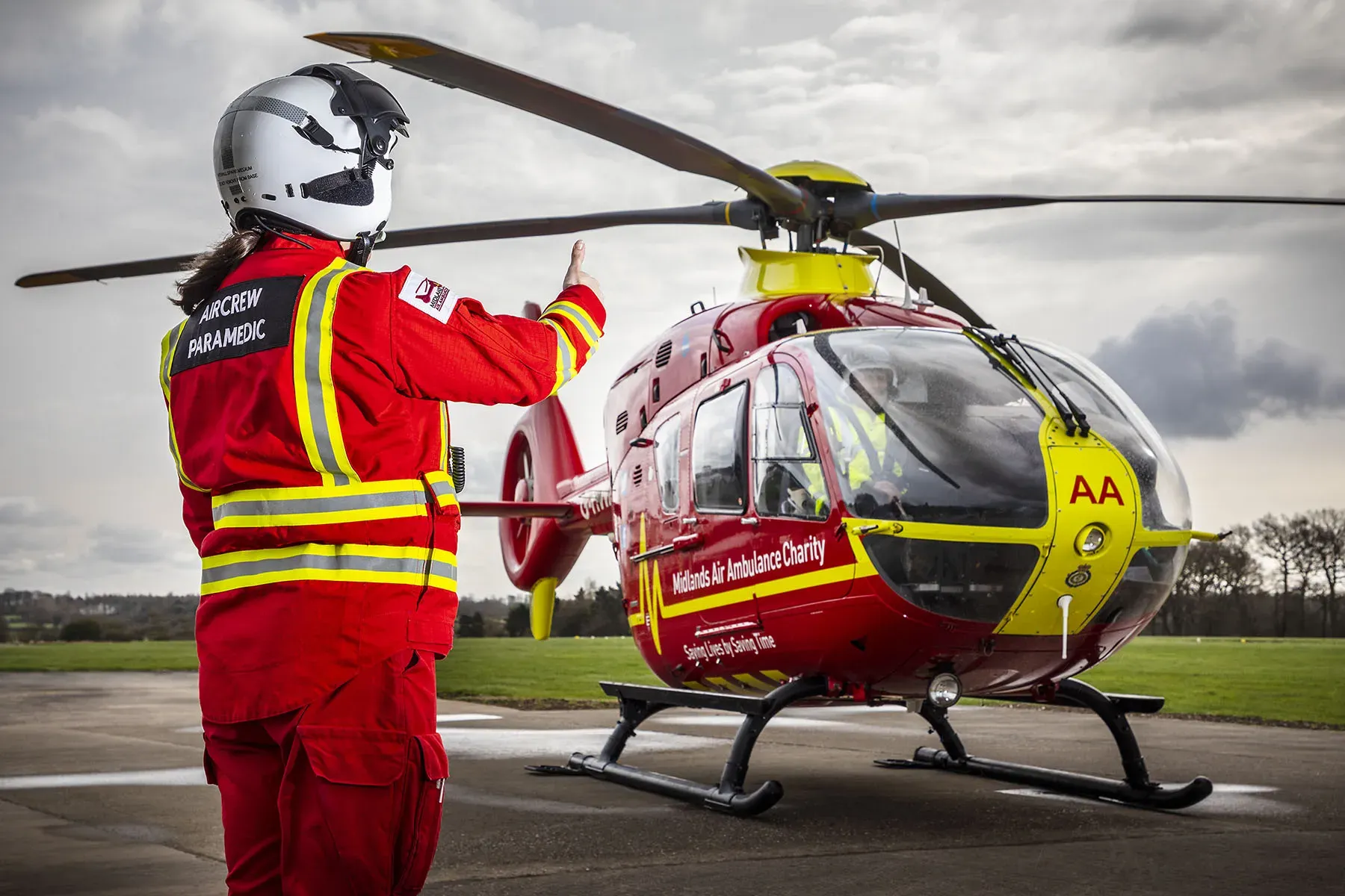 Maac Rescue Helicopter With A Man In Red Uniform Standing Next To It