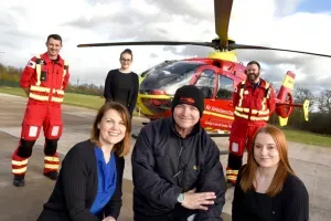 Maac Rescue Team Posing For A Picture With A Helicopter In The Background