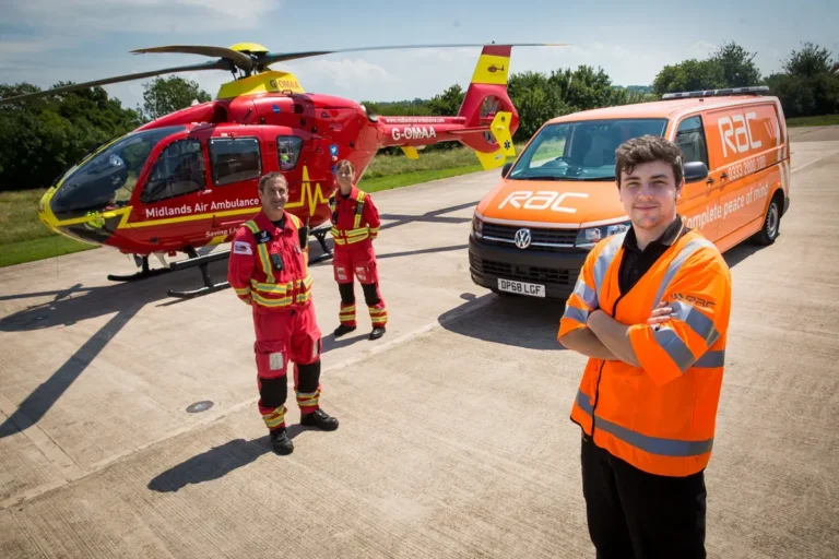 Maac Rescue Team Standing In Front Of A Helicopter And A Van