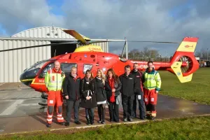 Maac Rescue Team Standing In Front Of A Helicopter On A Runway