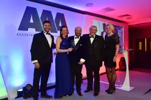 Maac Several People In Formal Attire Standing On Stage With A Man In A Tuxedo