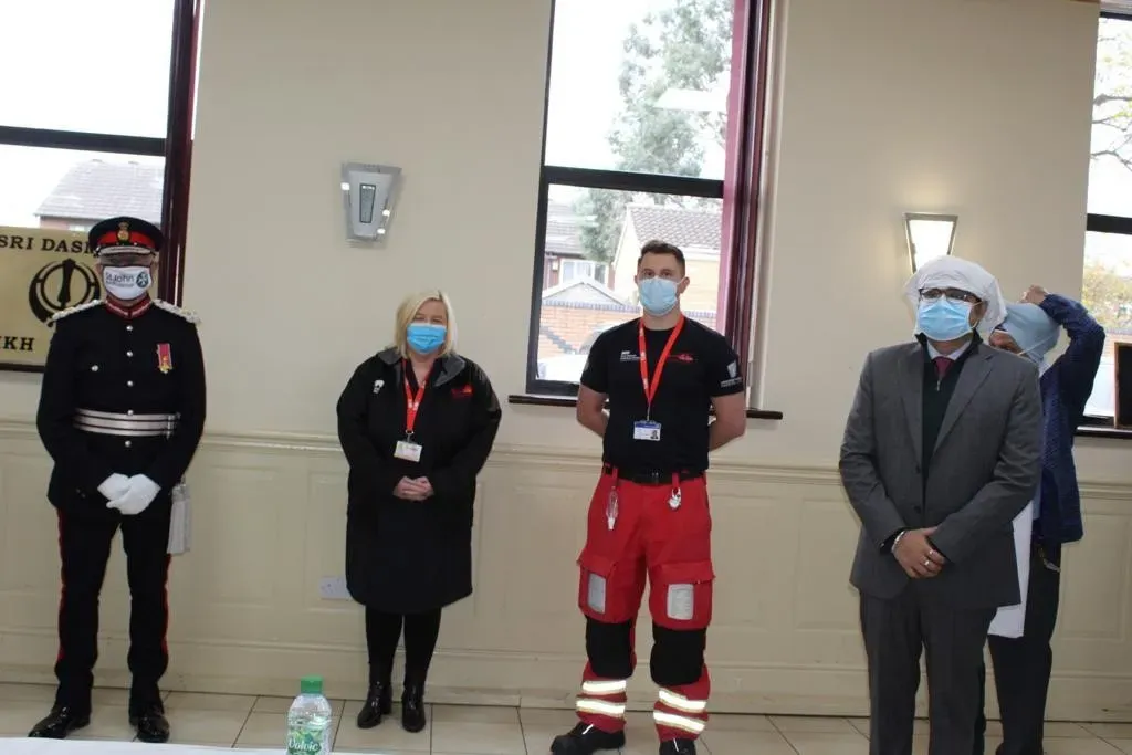 Maac Several People In Medical Gear Standing In A Room With A Man In A Suit