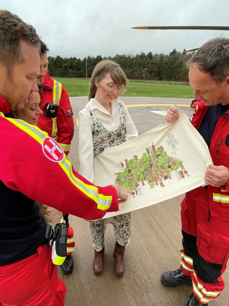 Maac Several People In Red And Yellow Uniforms Are Looking At A Drawing