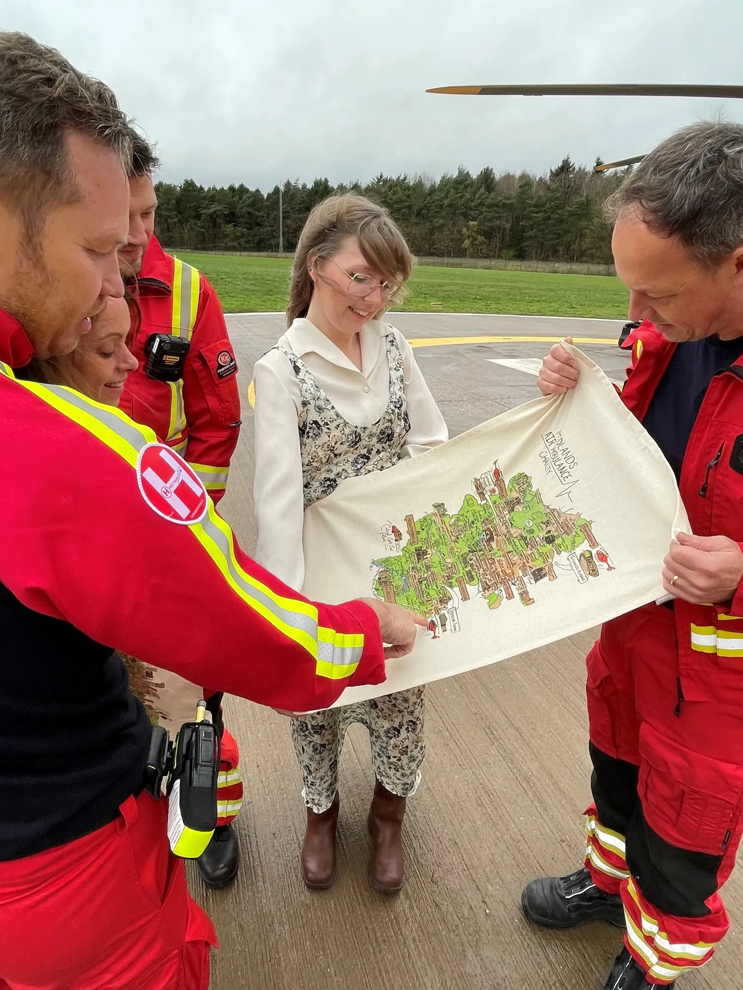Maac Several People In Red And Yellow Uniforms Are Looking At A Drawing