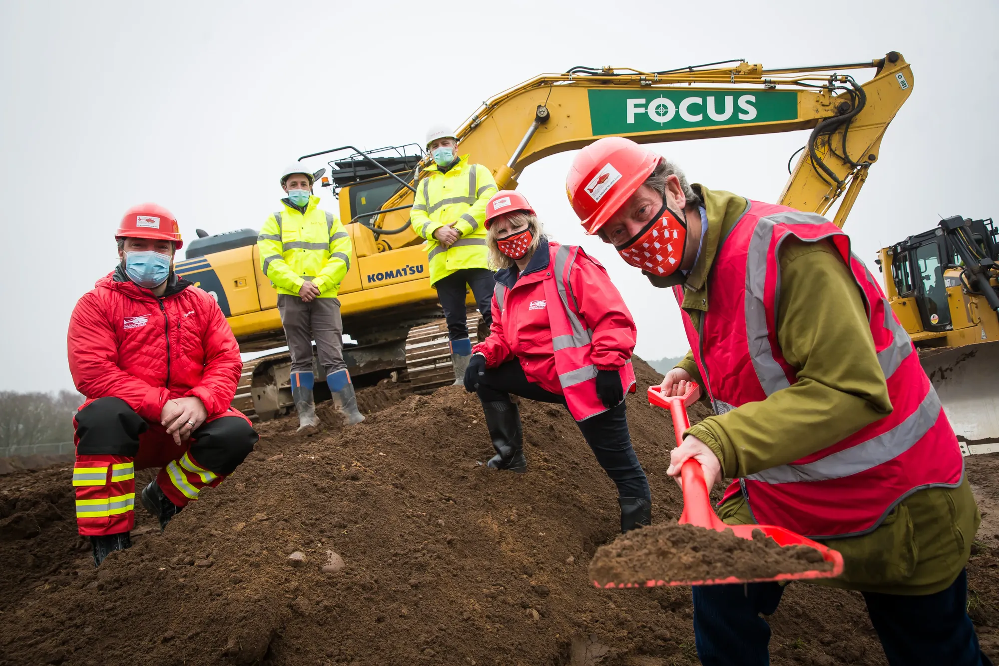 Maac Several People In Safety Gear Are Standing Around A Construction Site