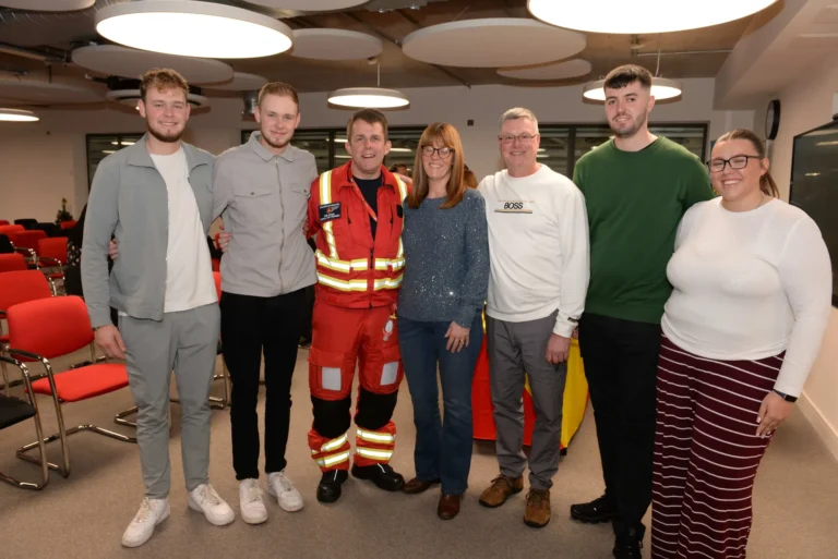 Maac Several People Standing In A Room With Red Chairs And A Fireman