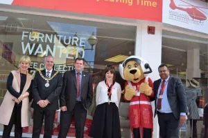 Maac Several People Standing In Front Of A Furniture Warehouse With A Mascot