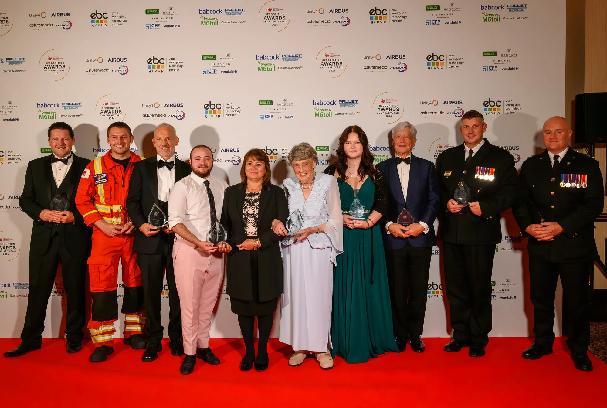 Maac Several People Standing In Front Of A Wall Holding Awards