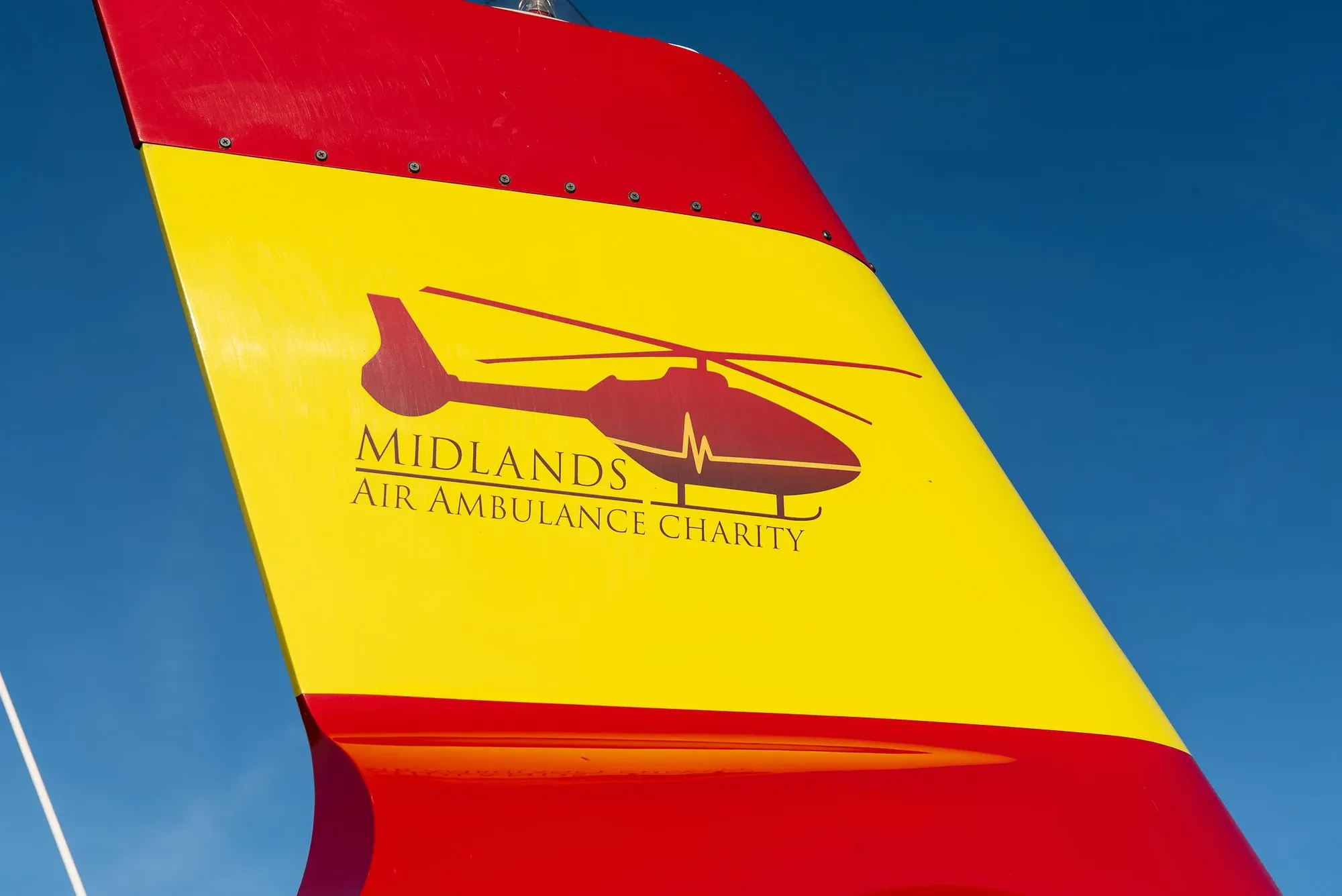 Maac Sign With A Helicopter On It And A Blue Sky In The Background