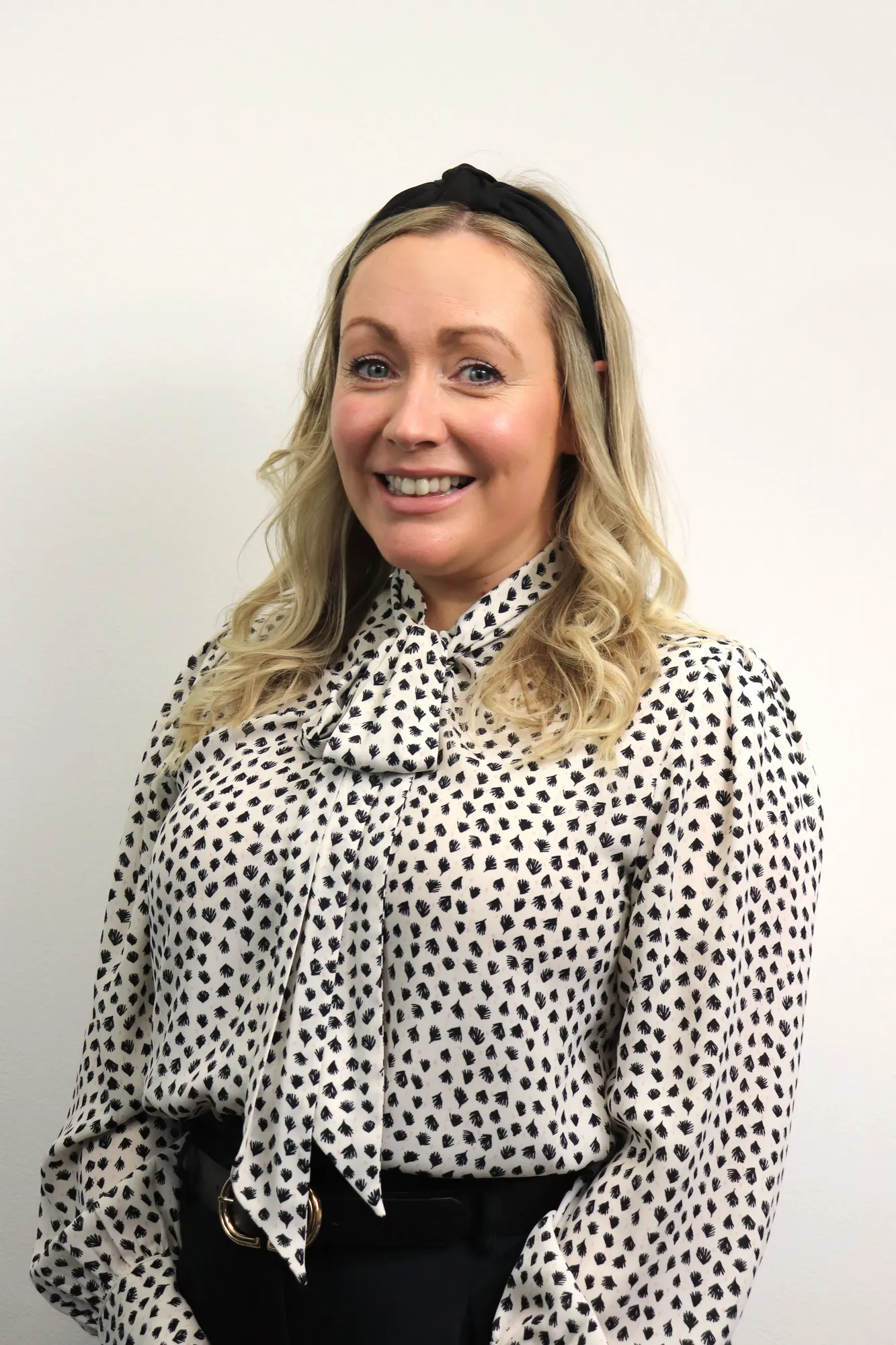 Maac Smiling Woman In Black And White Polka Dot Blouse With Black Bow