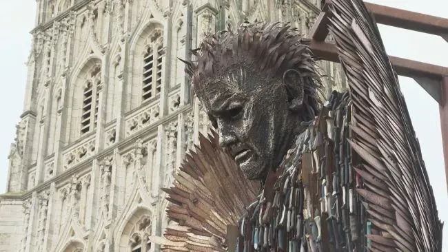 Maac Statue Of A Man With A Feather In Front Of A Cathedral