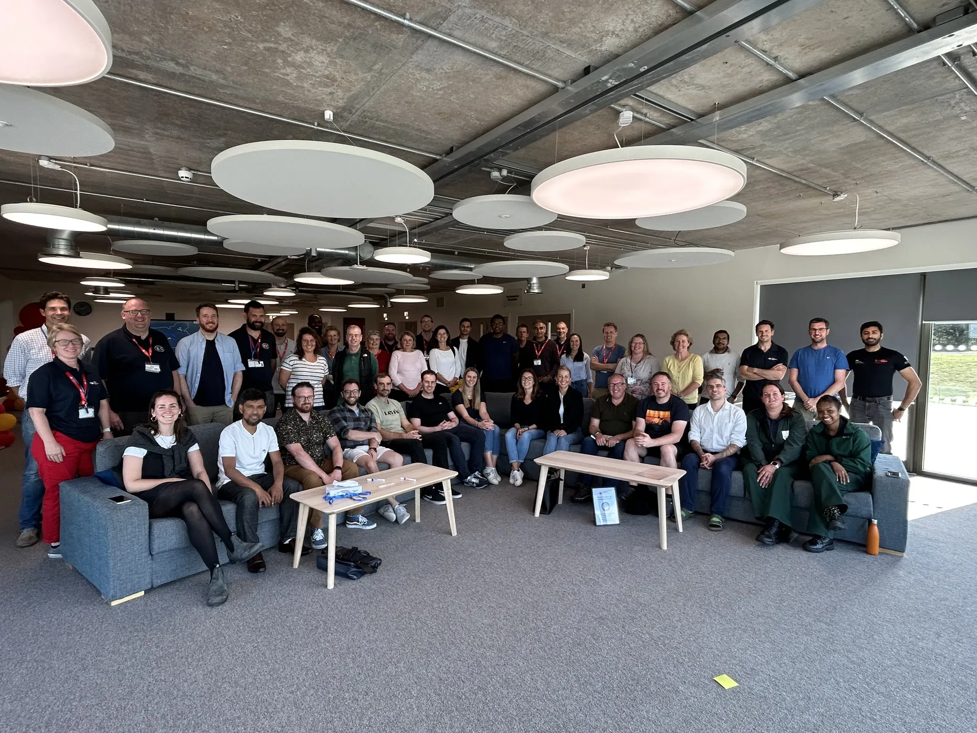 Maac There Are Many People Standing And Sitting In A Room Together
