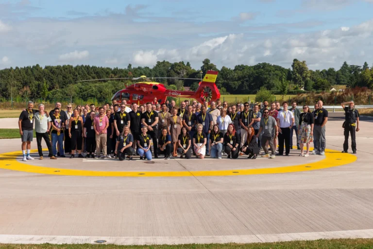Maac There Are Many People Standing In Front Of A Helicopter On The Tarmac