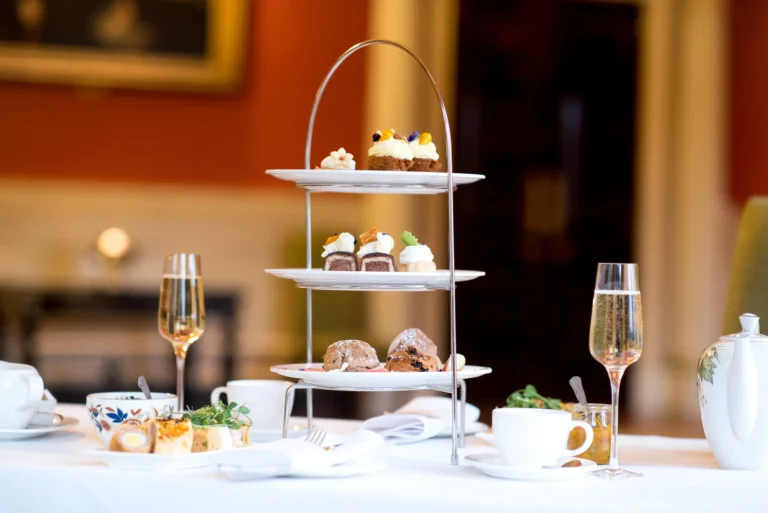 Maac There Are Three Tiered Trays With Desserts And Champagne On A Table