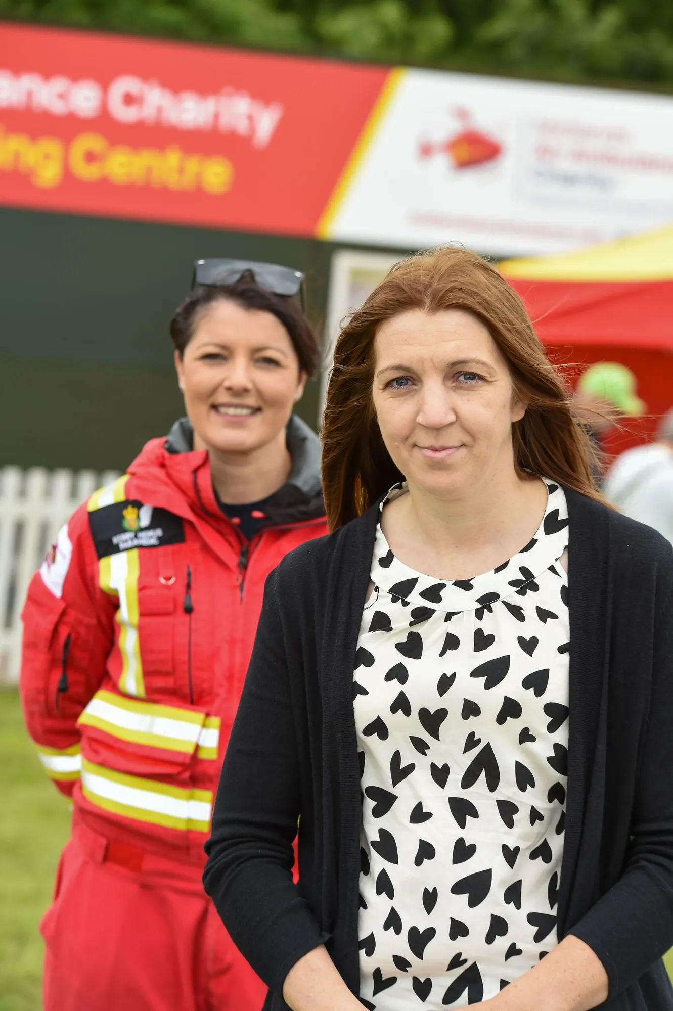 Maac There Are Two Women Standing Next To Each Other In A Field