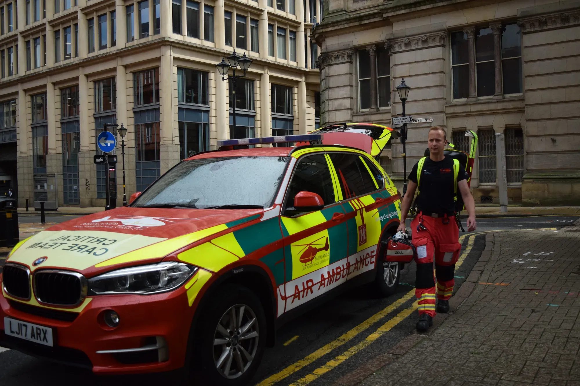 Maac There Is A Man Standing Next To A Car With A Fireman On It