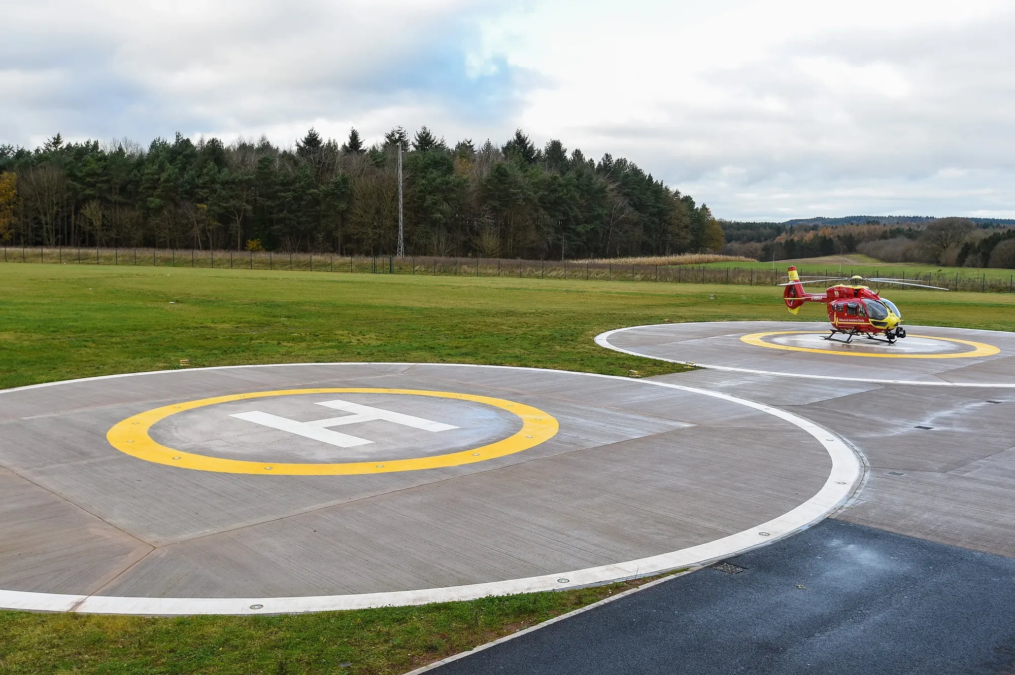 Maac There Is A Small Red Helicopter On The Runway At The Airport
