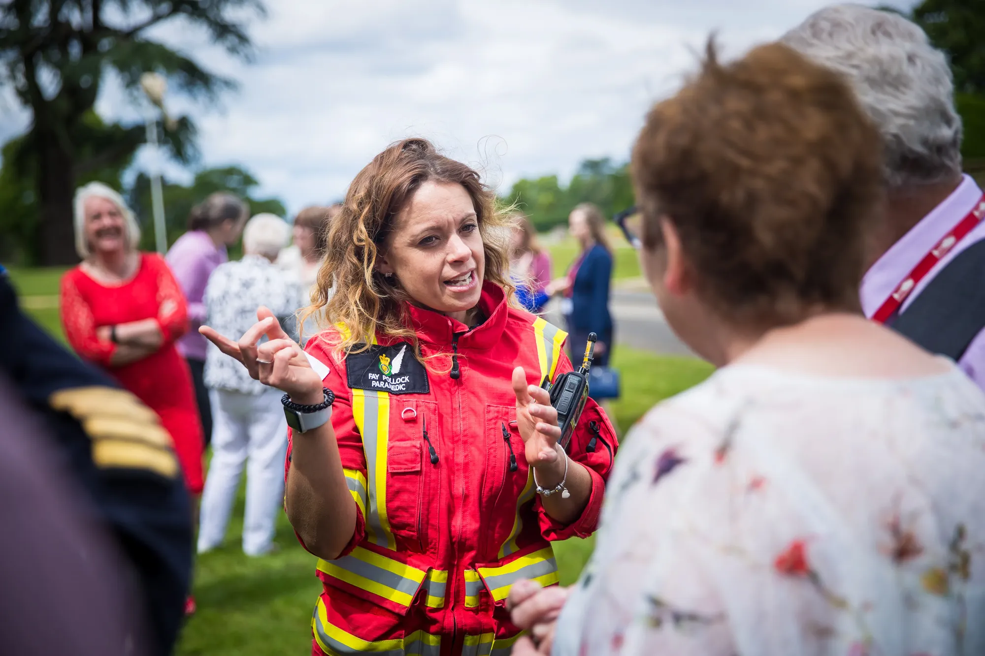 Maac There Is A Woman In A Red Firefighter Uniform Talking To A Group Of People