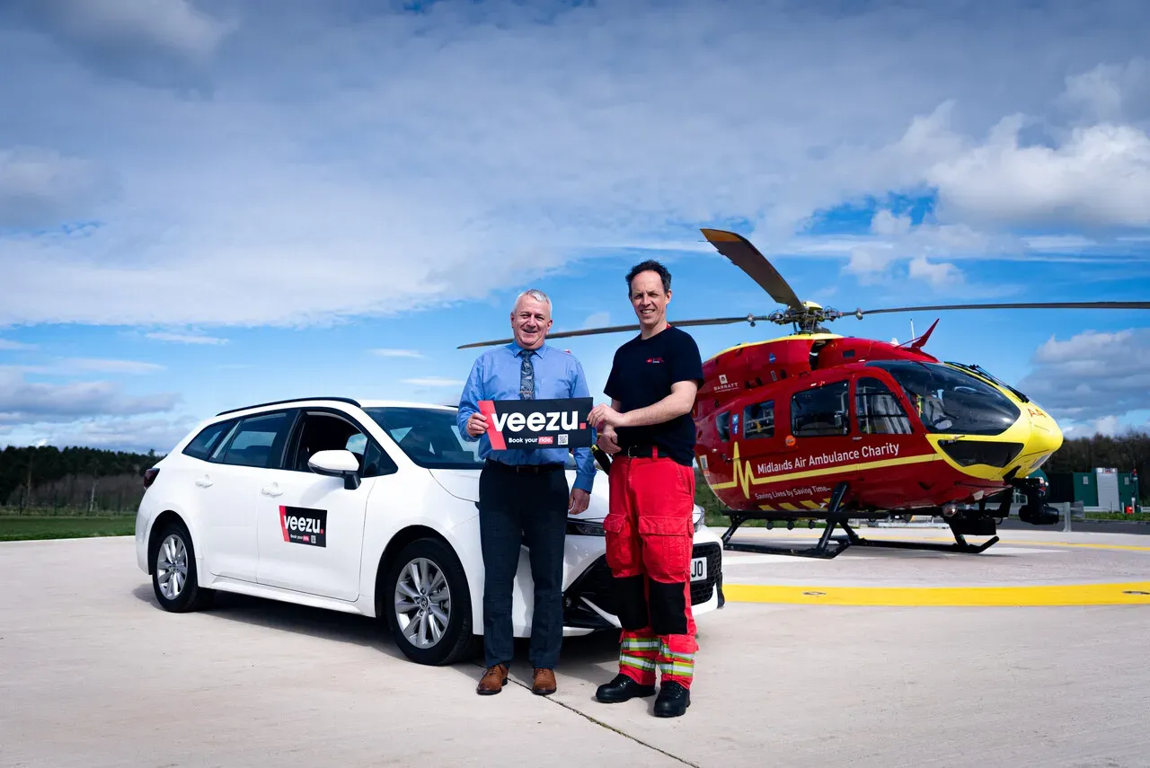 Maac They Are Standing Next To A Car And A Helicopter