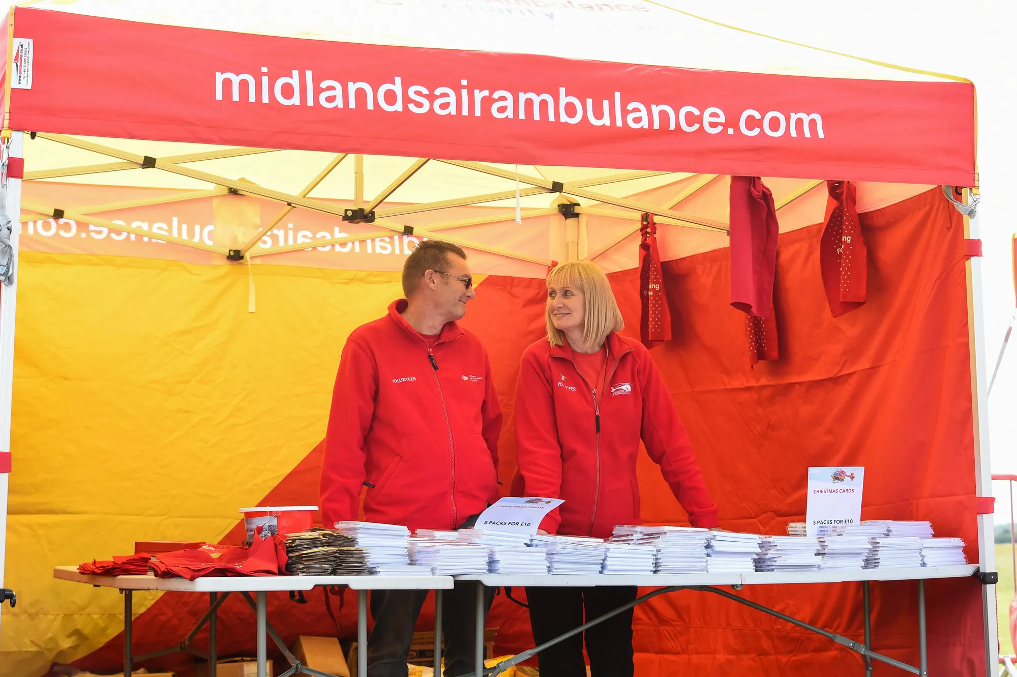 Maac They Are Standing Under A Tent With A Table Full Of Books
