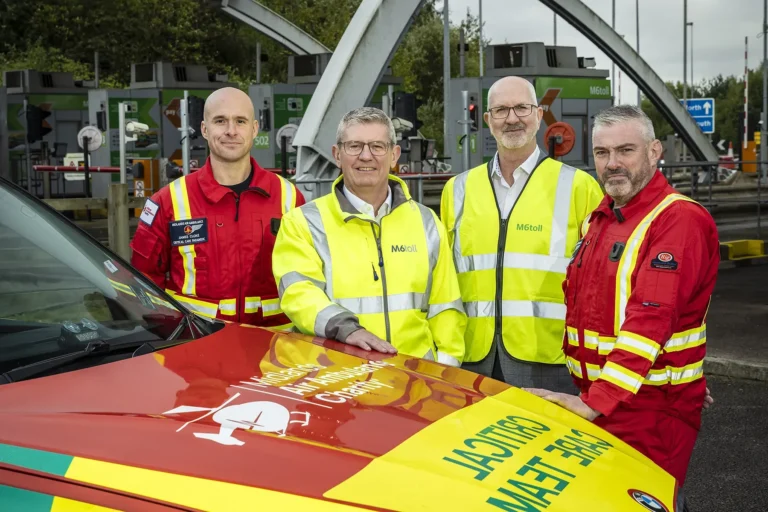 Maac Three Men In Yellow Jackets Standing Next To A Red And Yellow Car