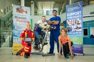 Maac Three People In Blue Uniforms Posing With A Robot In A Building
