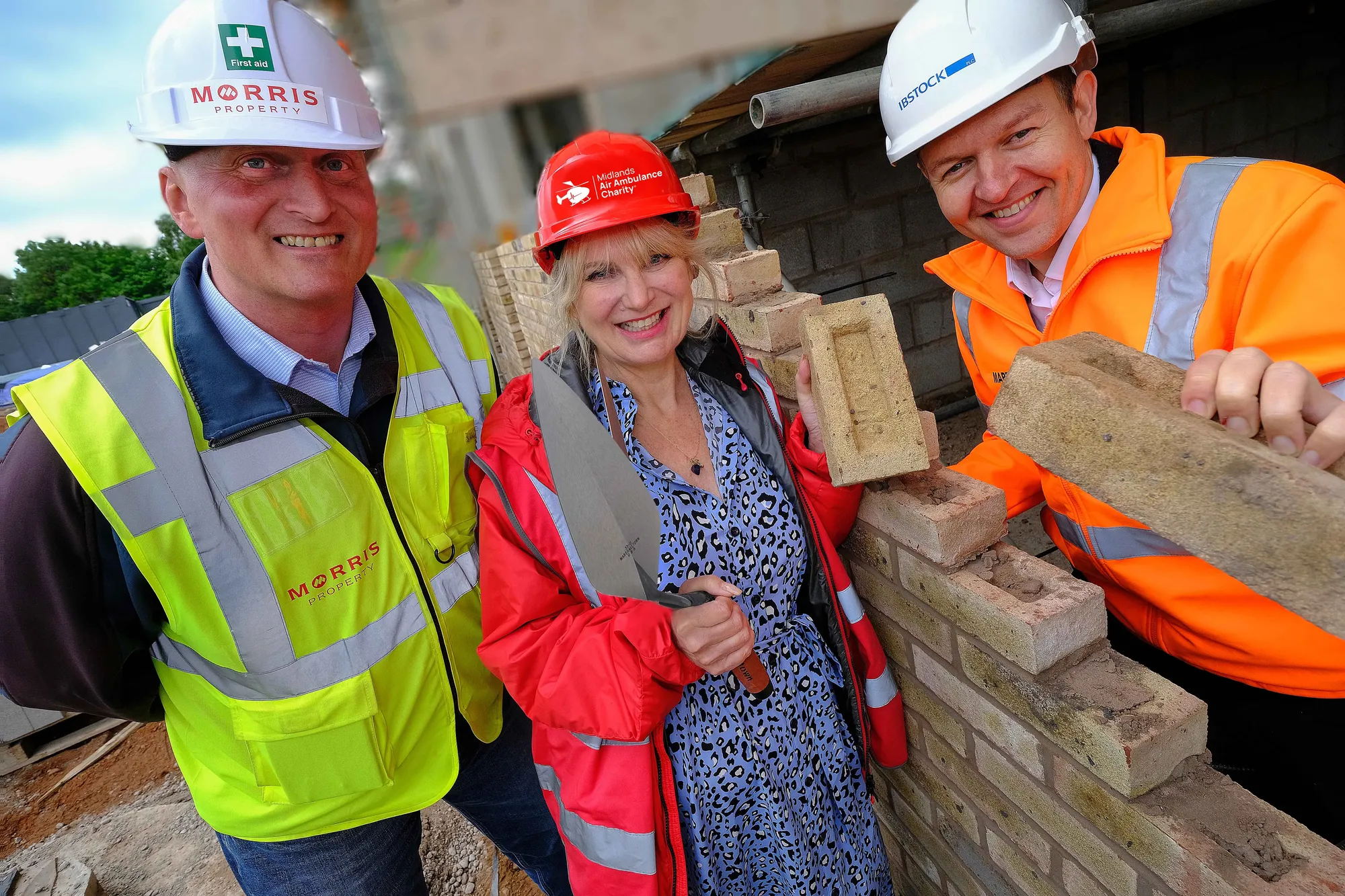 Maac Three People In Hard Hats And Safety Vests Standing Next To A Brick Wall