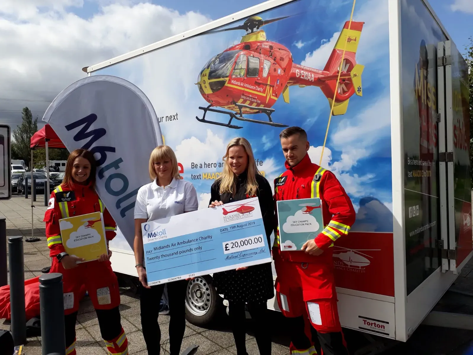Maac Three People In Red Uniforms Holding A Check For 1 000