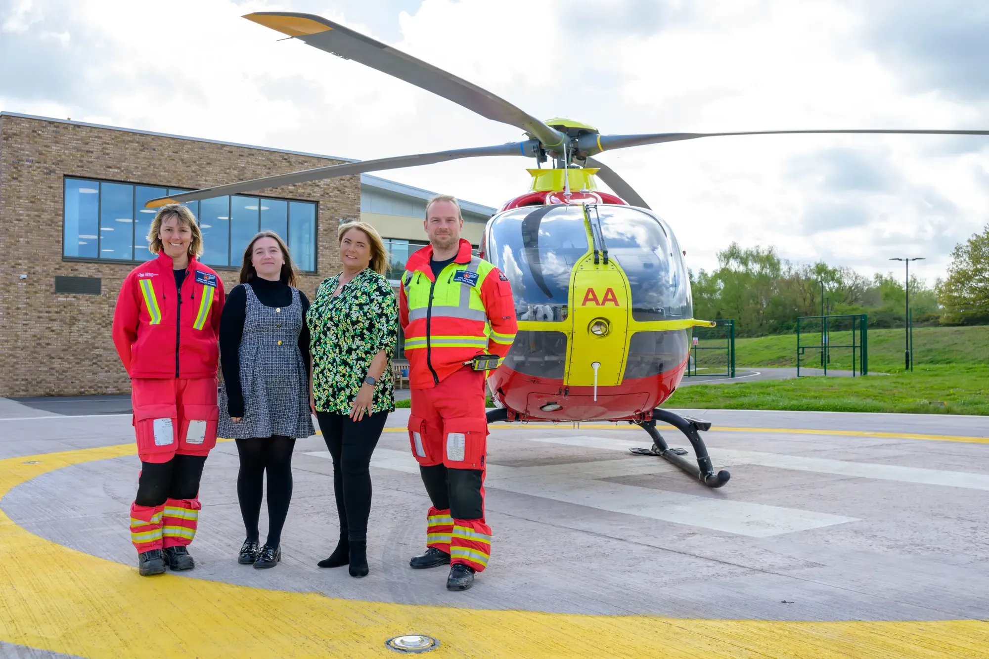Maac Three People Standing In Front Of A Helicopter With A Woman Standing Beside Them