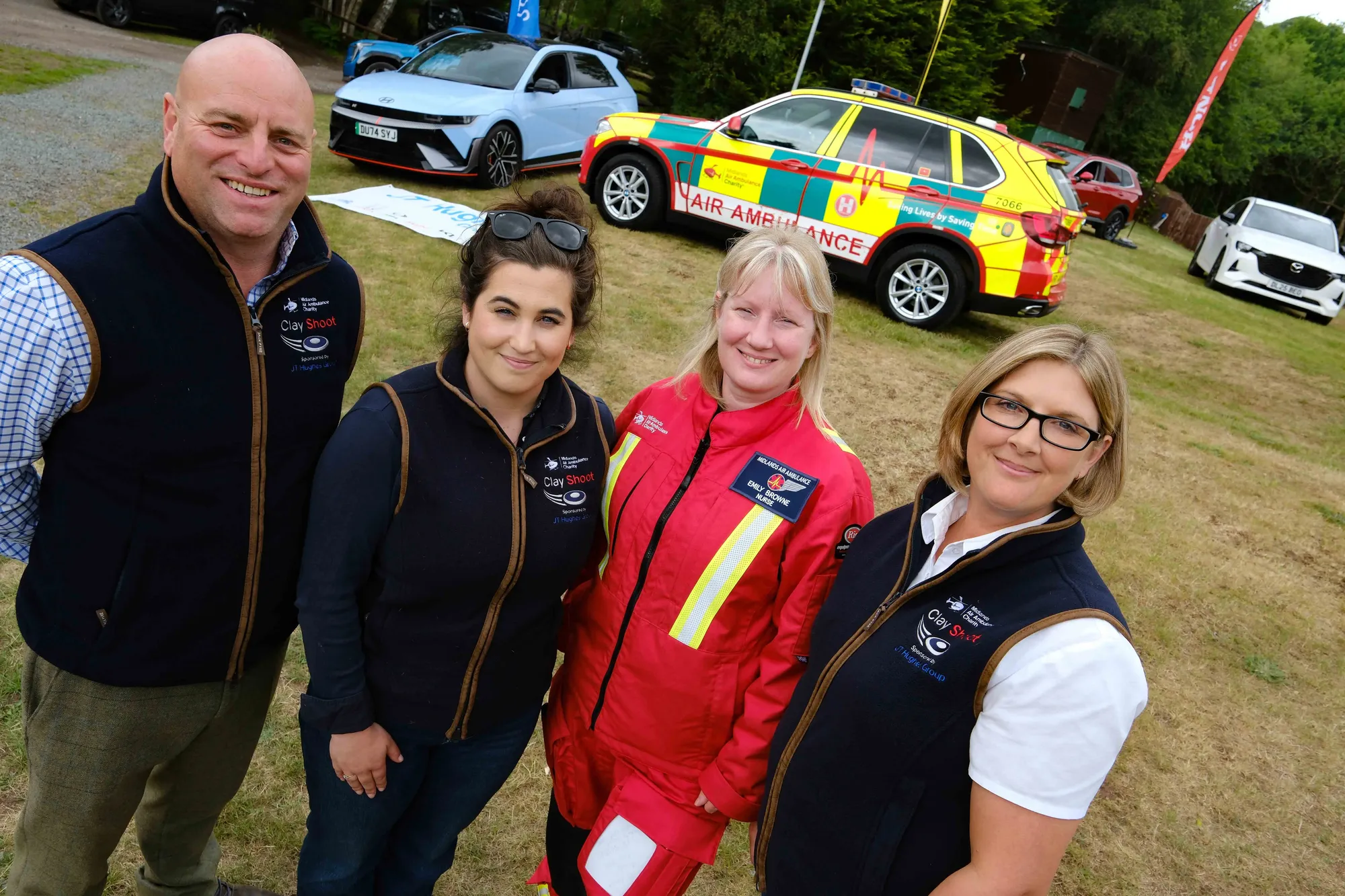Maac Three Women And A Man Standing Next To A Car In A Parking Lot