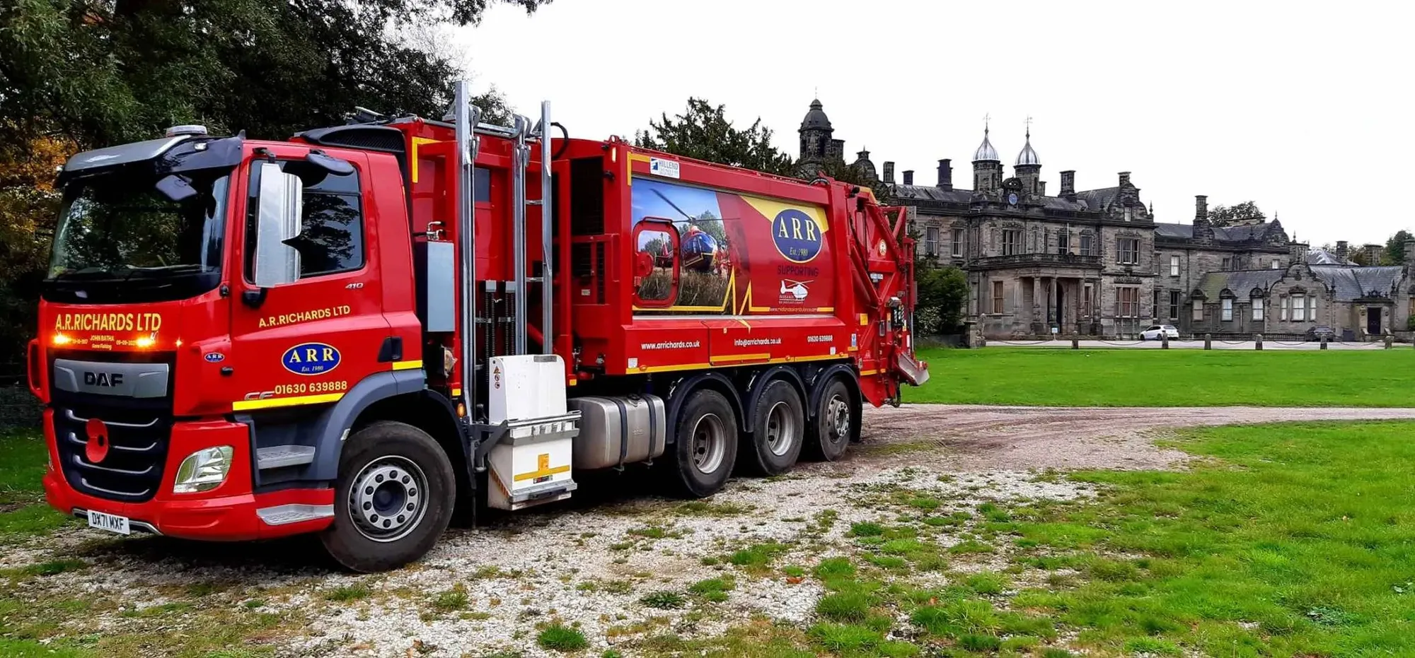 Maac Truck Parked In Front Of A Castle With A Large Building In The Background