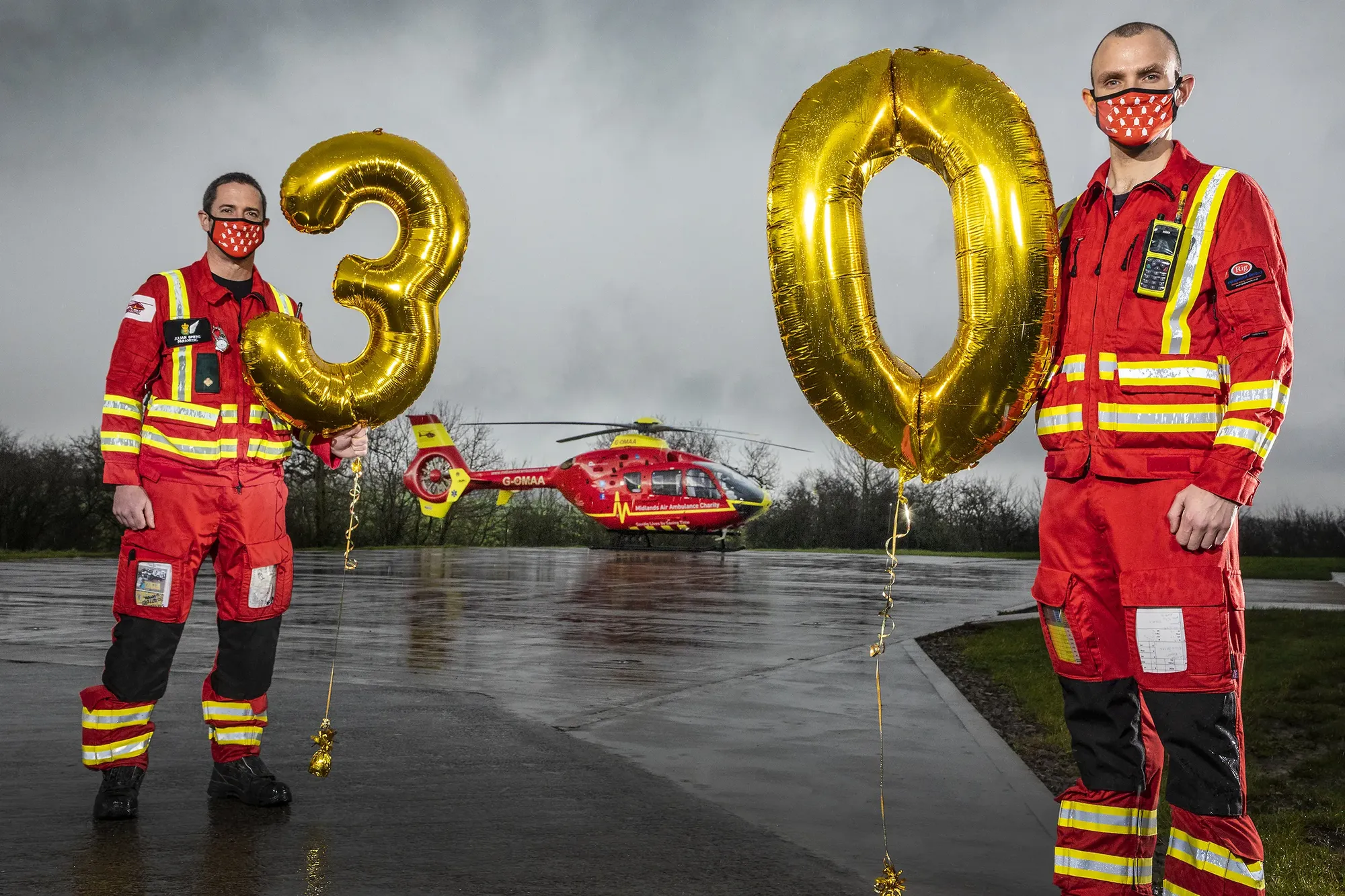Maac Two Firemen In Red Uniforms Holding Up Balloons And A Helicopter