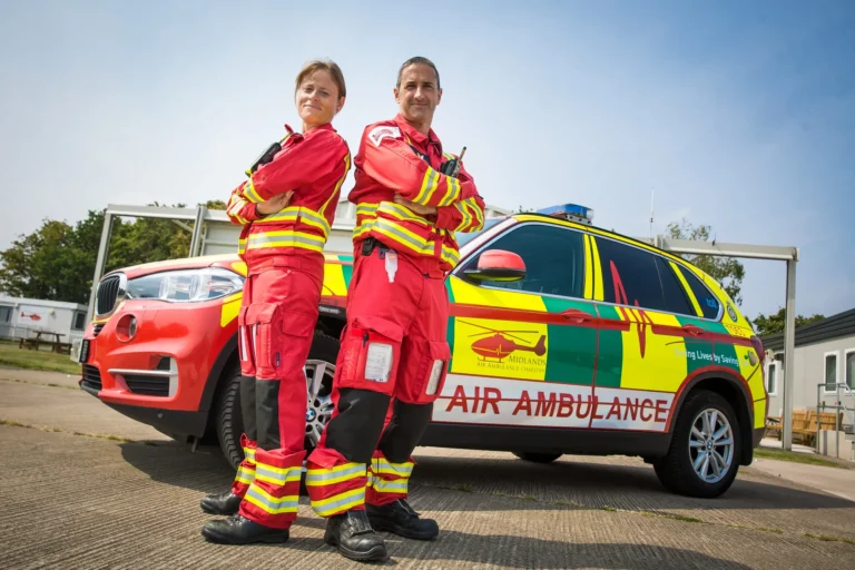 Maac Two Women In Fire Uniforms Standing Next To A Car