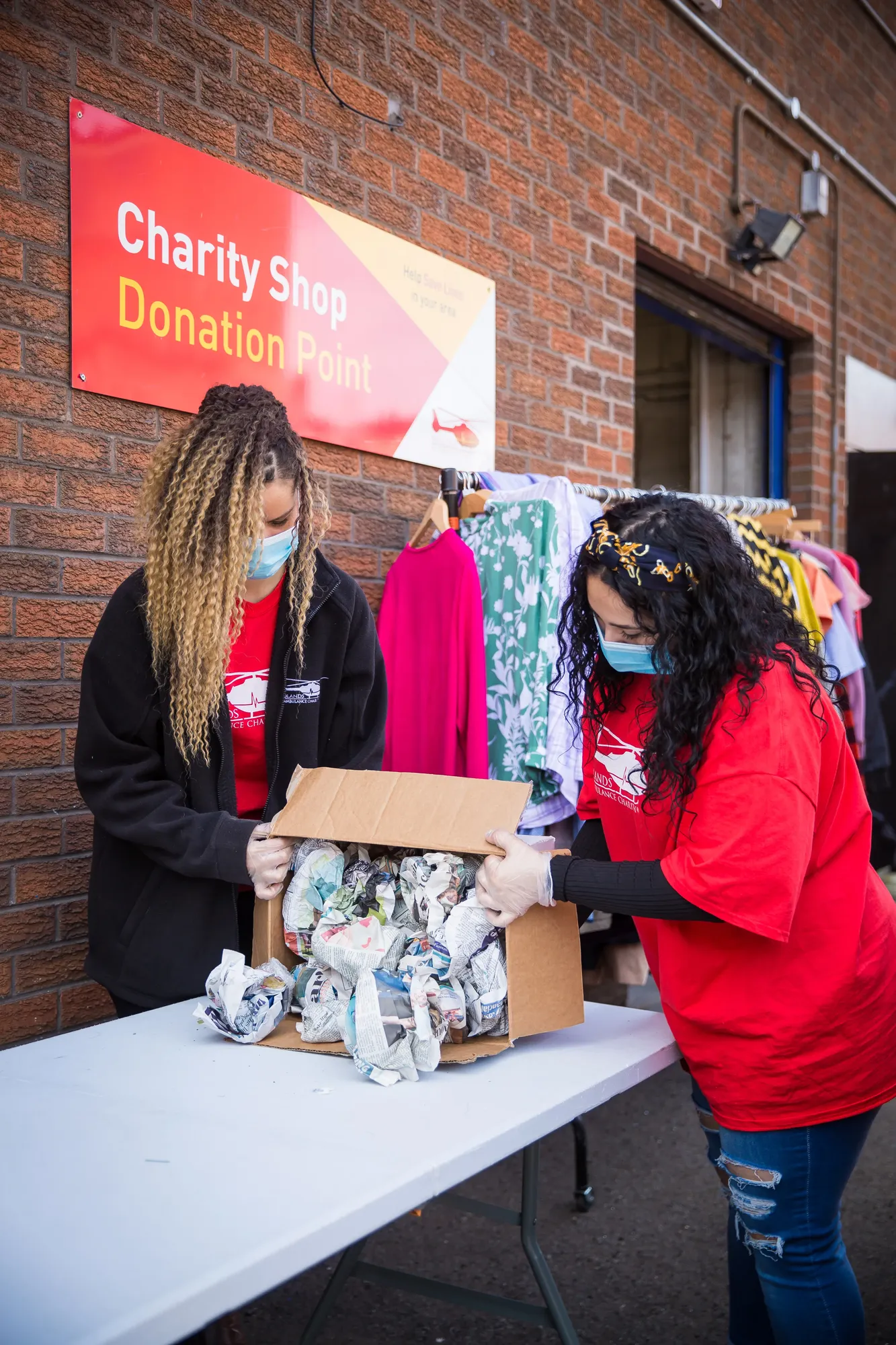 Maac Two Women In Red Shirts And Masks Are Handing Out Donations