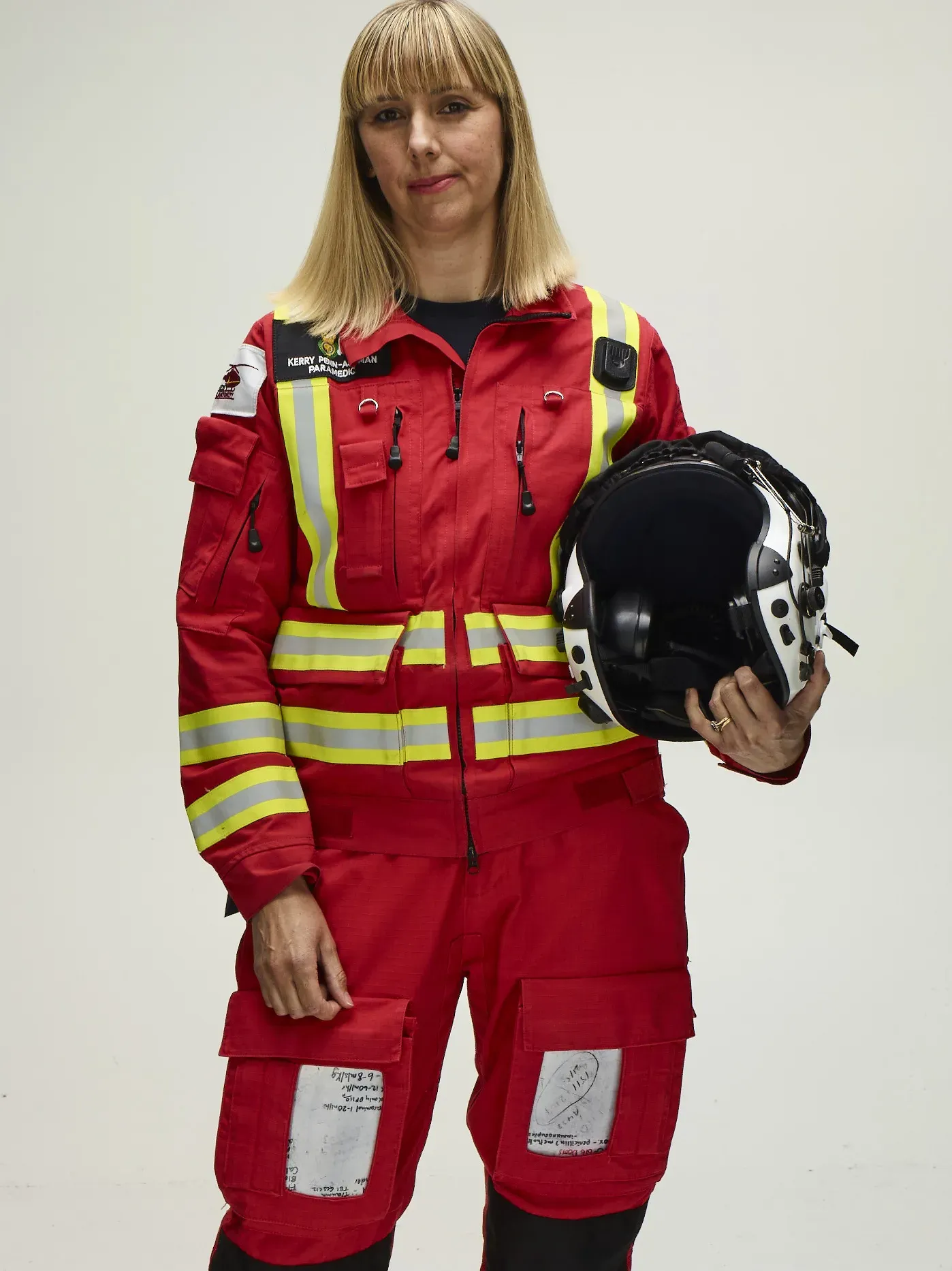 Maac Woman In A Red Fire Suit Holding A Helmet