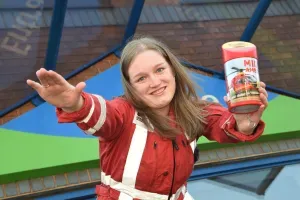 Maac Woman In Red Jacket Holding Up A Can Of Beer