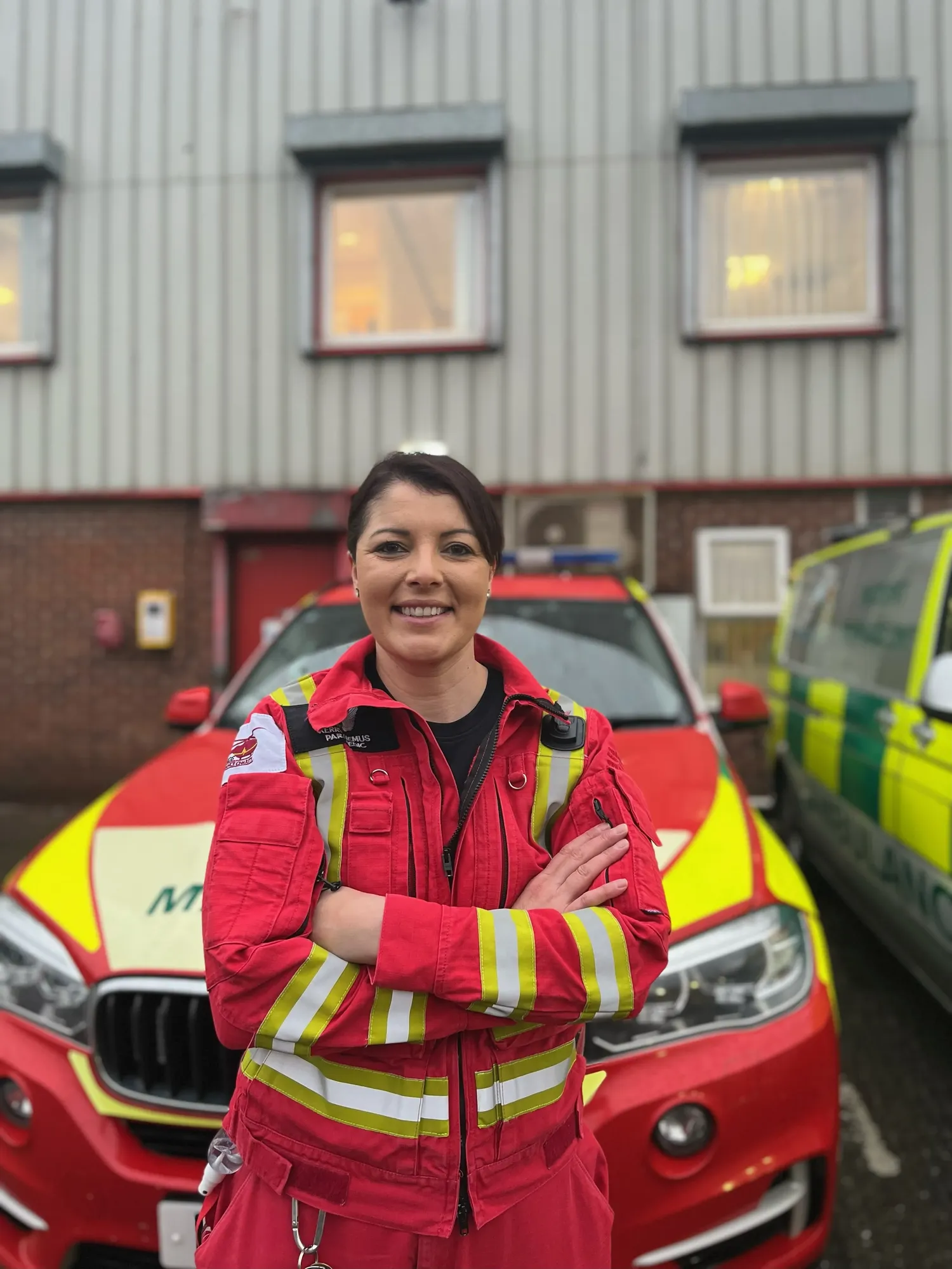Maac Woman In Red Jacket Standing In Front Of A Red Car