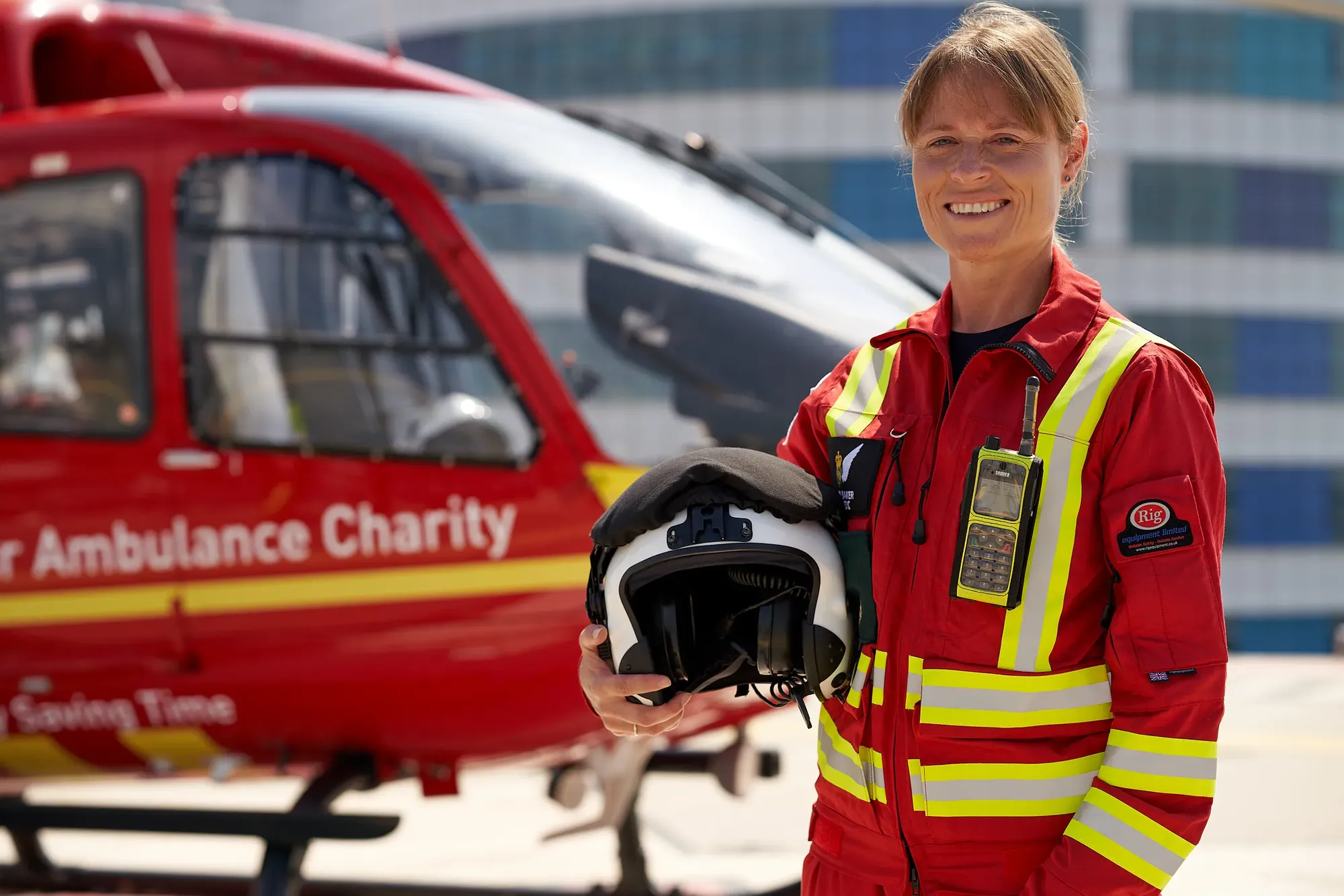 Maac Woman In Red Uniform Holding Helmet And Helmet In Front Of Helicopter