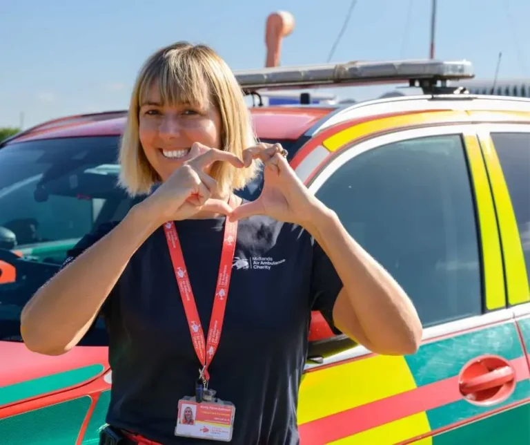Maac Woman Making A Heart Sign With Her Hands In Front Of A Police Car