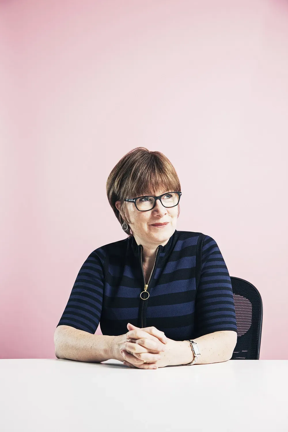 Maac Woman Sitting At A Table With Her Hands Folded