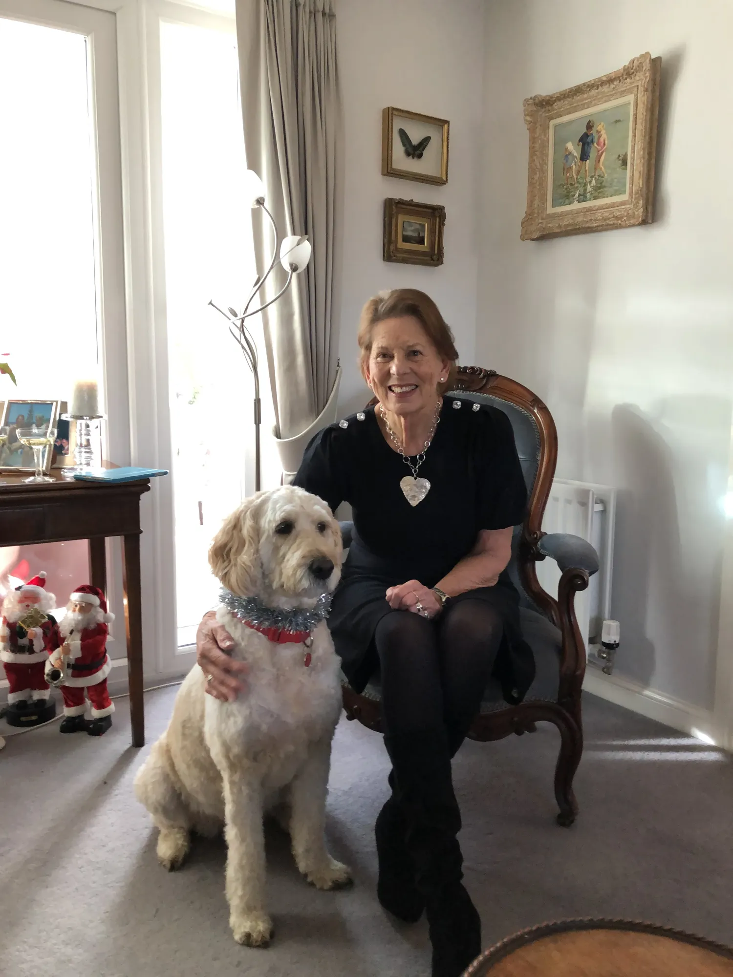 Maac Woman Sitting In A Chair With A Dog In Front Of Her