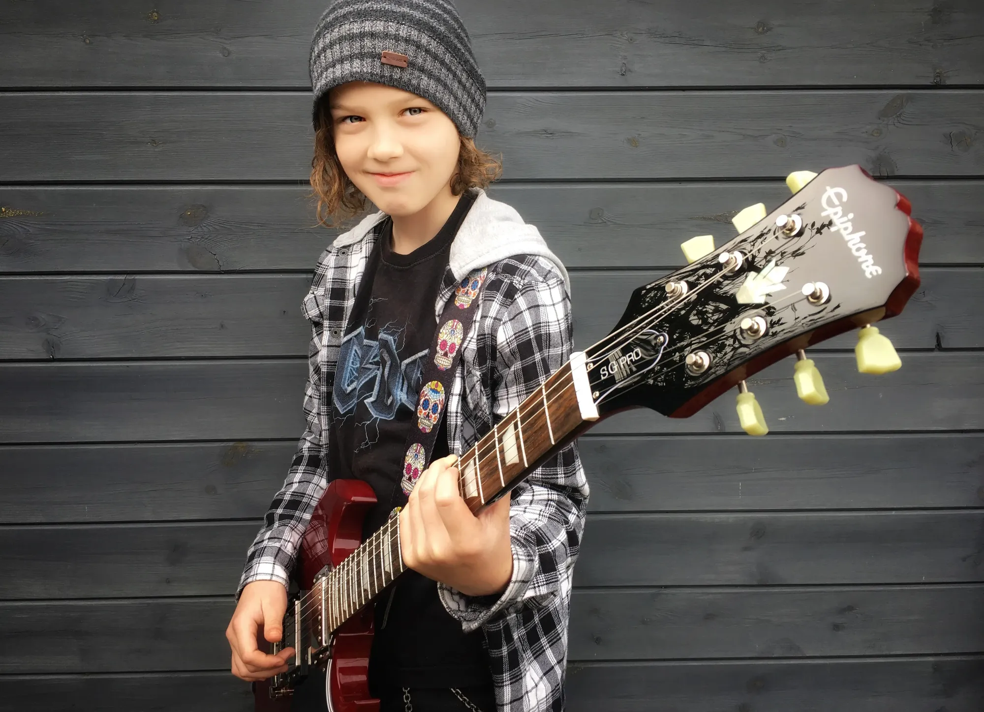 Maac Young Boy Holding A Guitar And Wearing A Hat